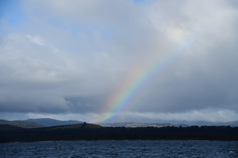 a rainbow in the sky over a body of water