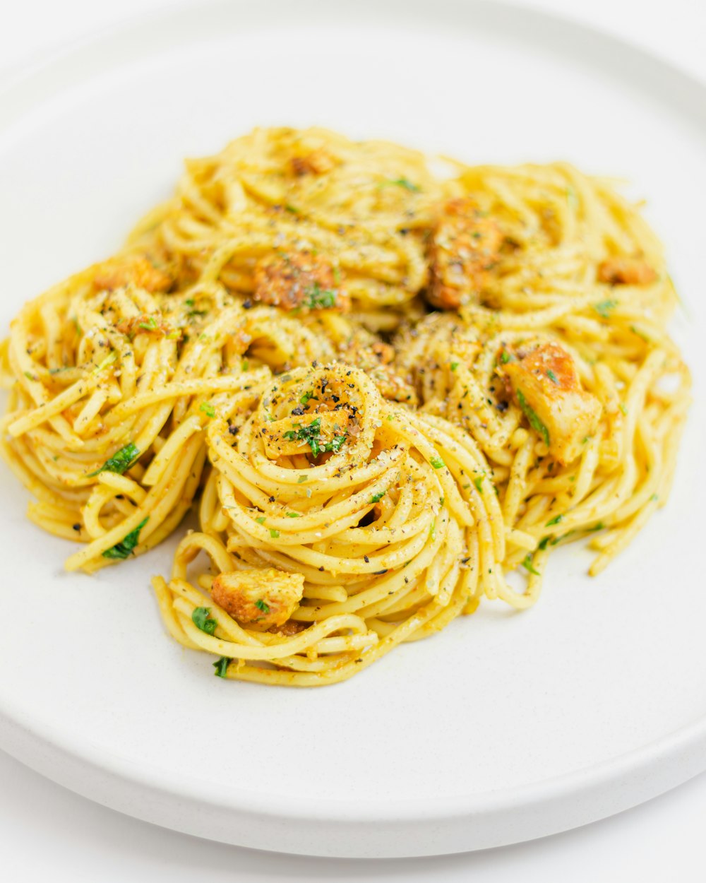 a white plate topped with pasta covered in sauce