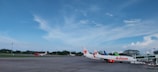 An aircraft parked on the tarmac with a clear blue sky overhead.