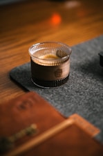 Close-up of a steaming espresso shot next to a rustic wooden table with soft morning light.