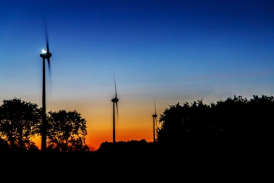 Close-up of a modern wind turbine spinning gently against a sunset.