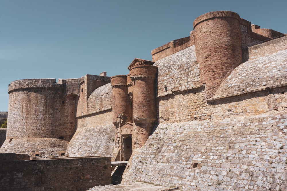 a large brick castle sitting next to a stone wall