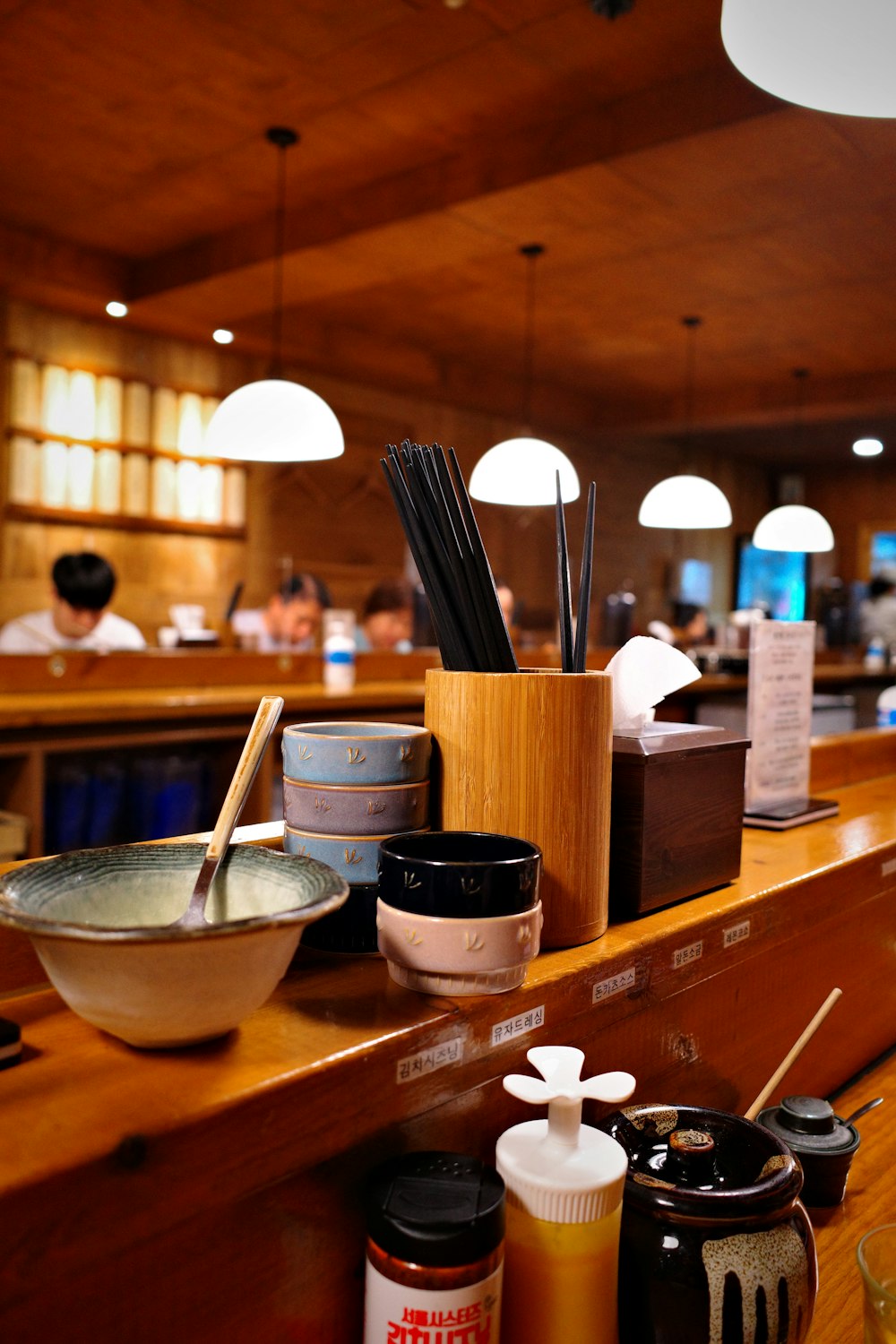 a wooden counter topped with bowls and chopsticks
