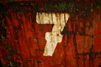 a number seven painted on a red wall