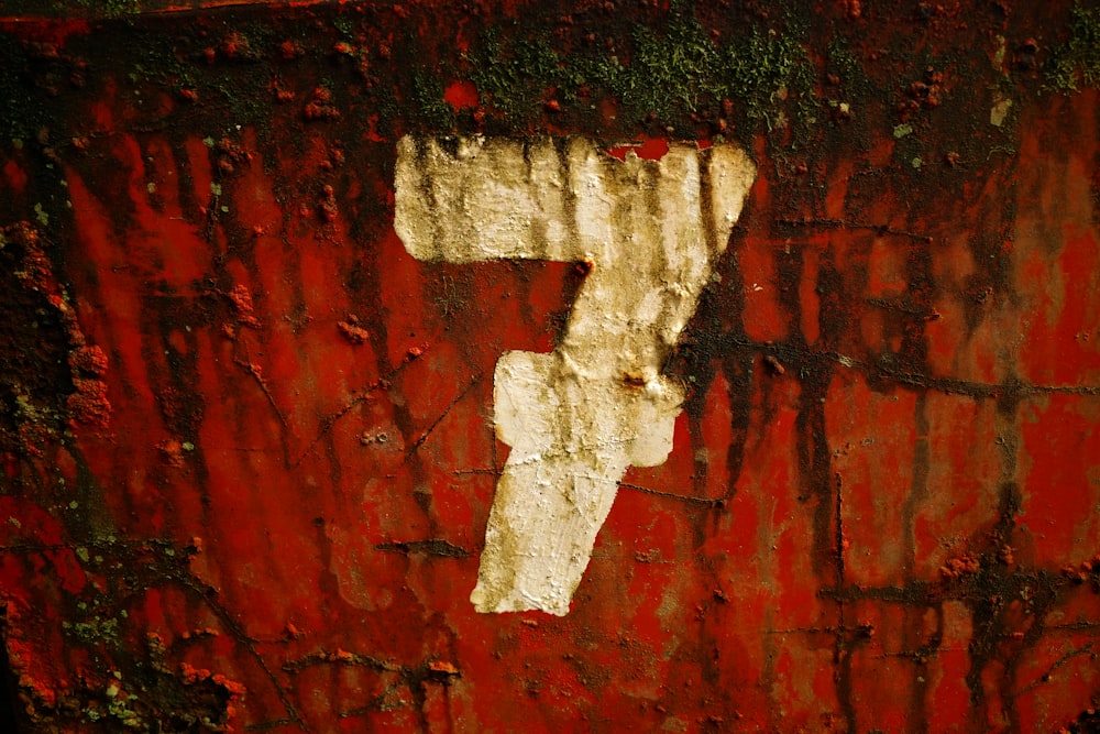 a number seven painted on a red wall