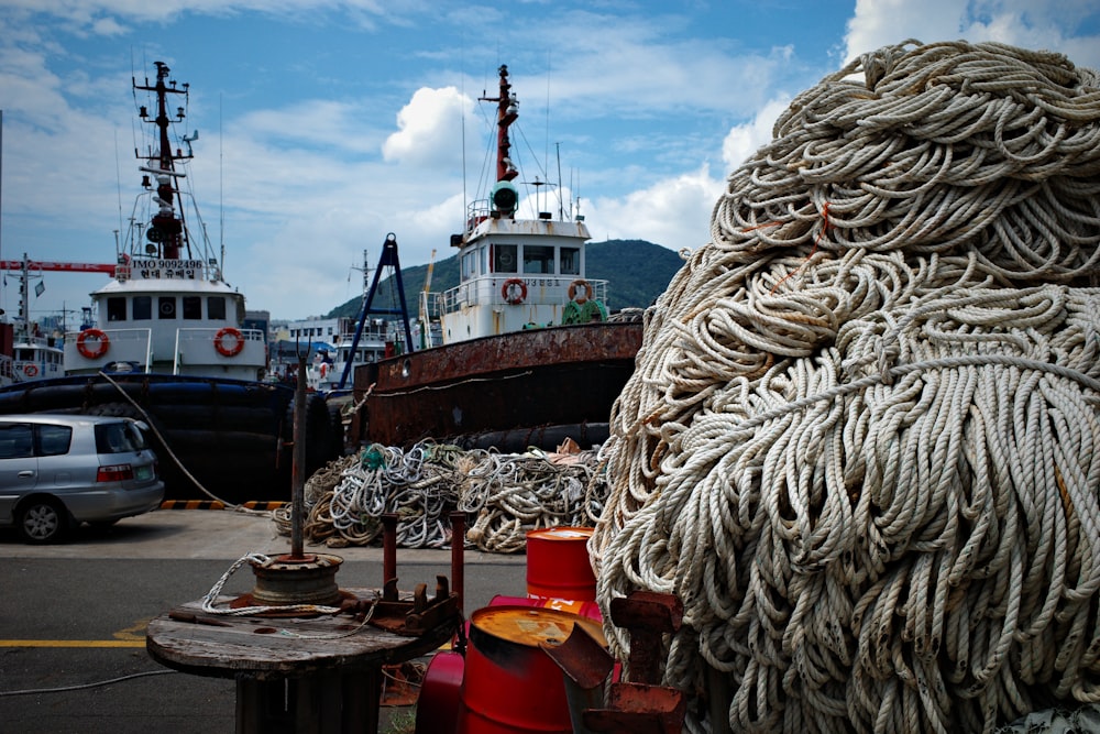 a large boat sitting next to a pile of rope