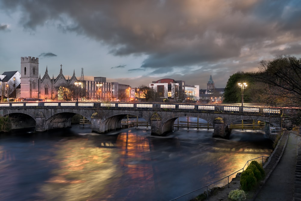 a bridge over a river with a city in the background