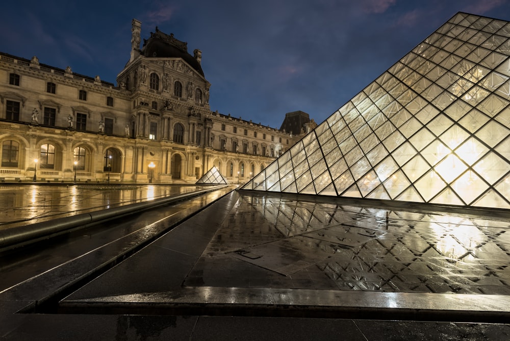 a large building with a very tall pyramid in front of it