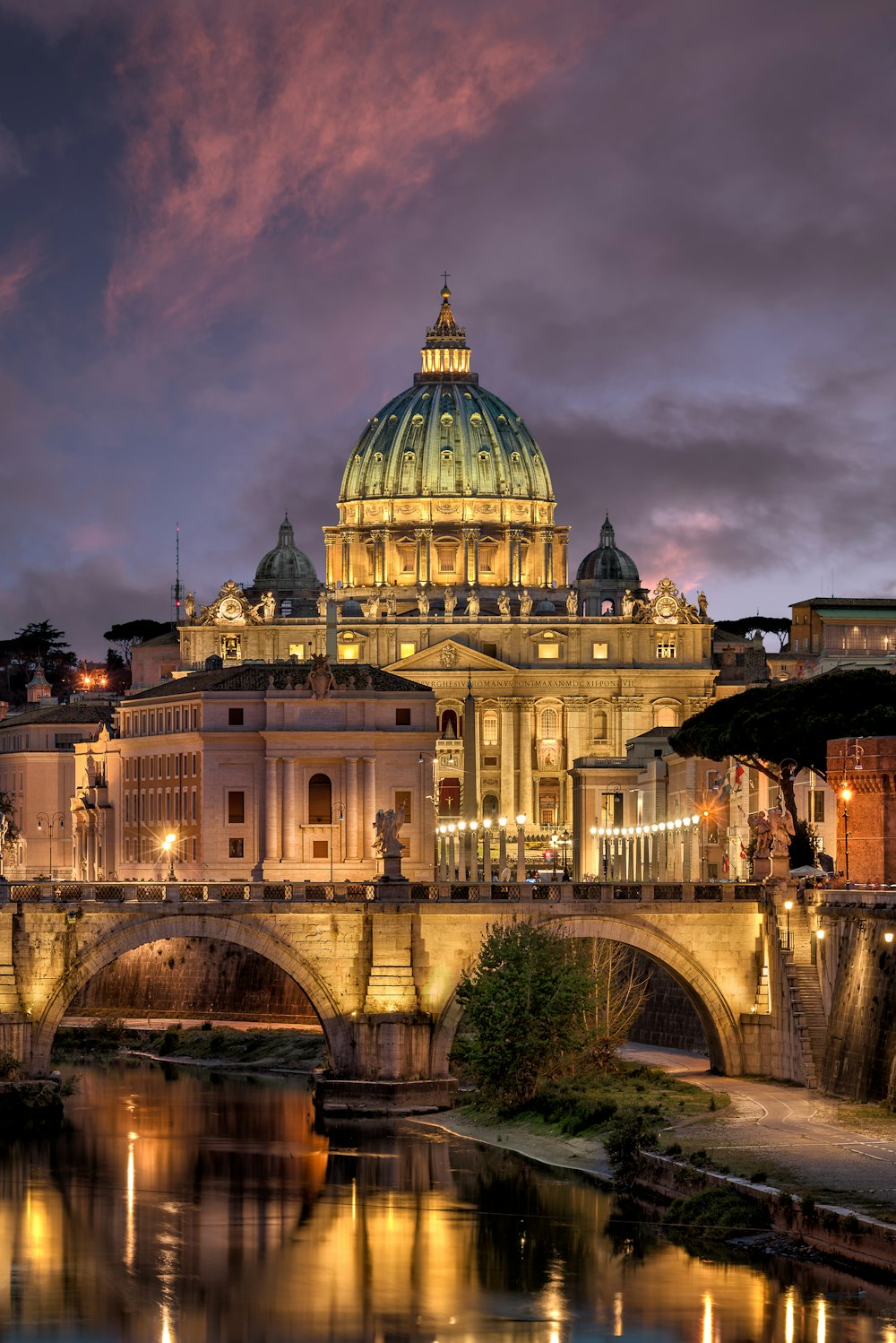 a large cathedral lit up at night over a river