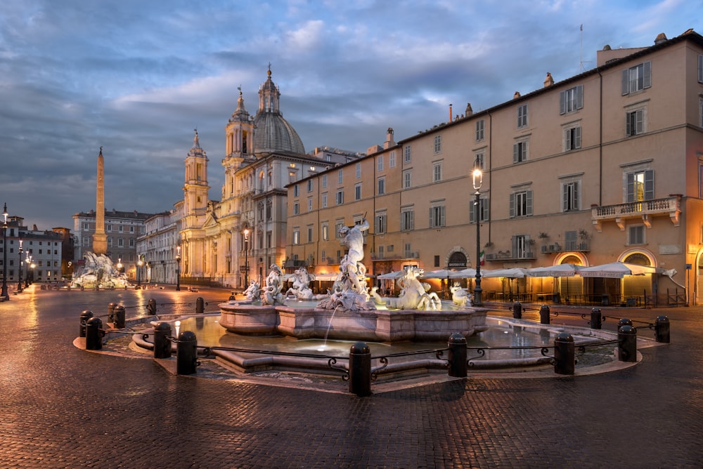 a city square with a fountain in the middle of it