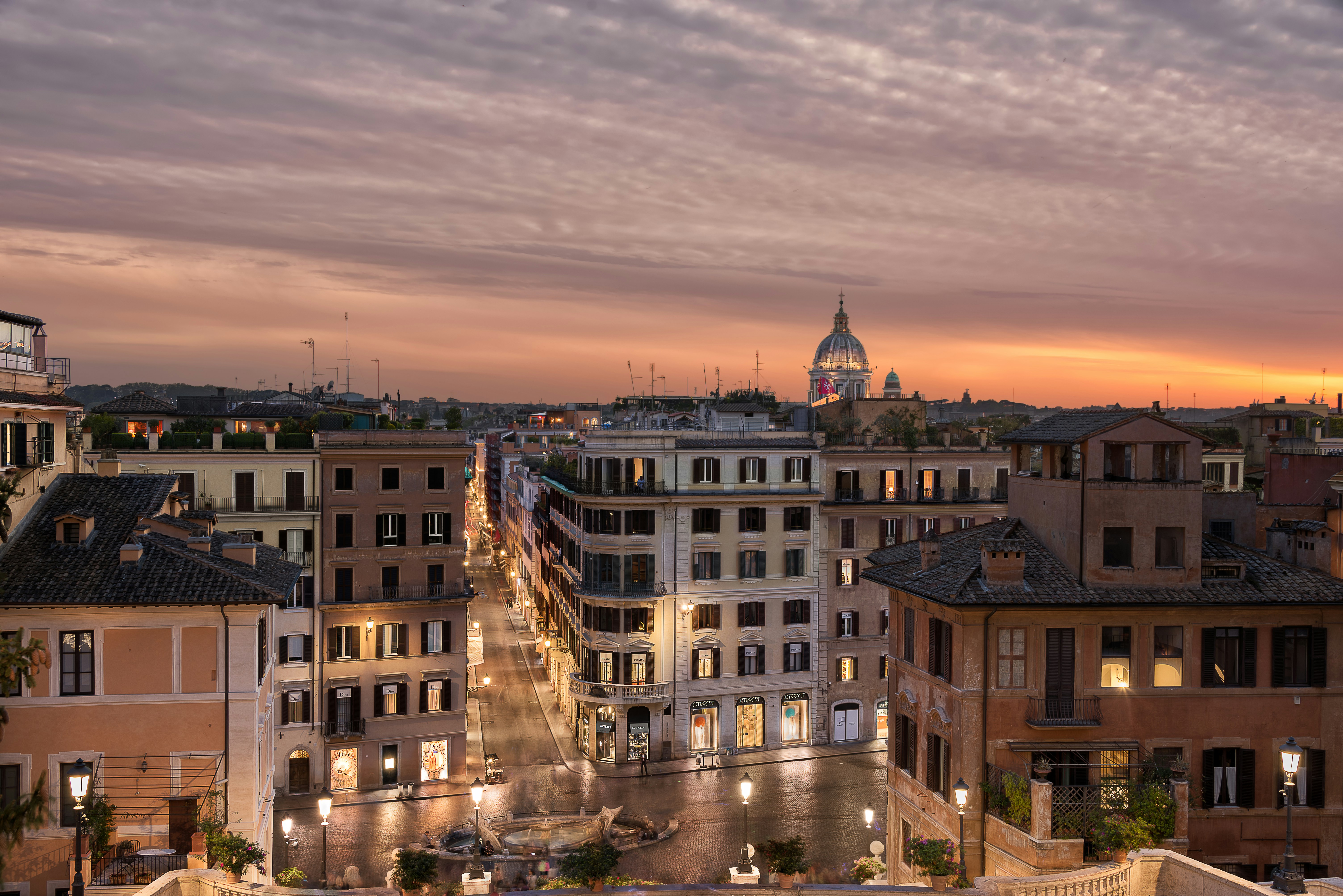Blick auf eine Stadt in der Abenddämmerung mit einem Glockenturm in der Ferne