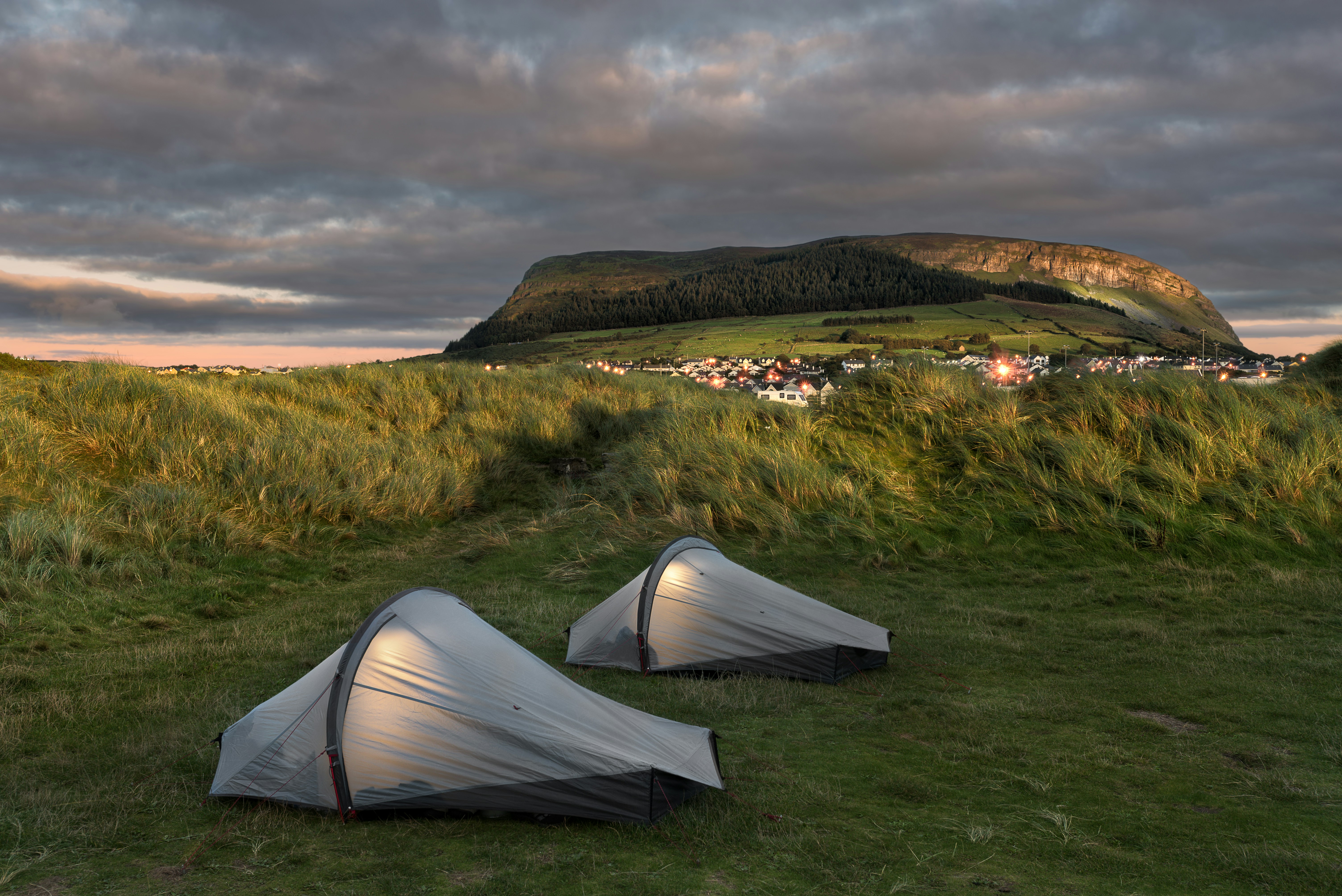 a couple of tents sitting on top of a lush green field