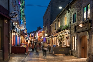 A cozy street in Búzios lined with colorful shops and lively cafes during sunset.