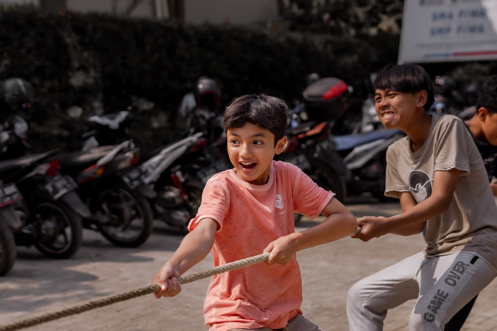 two young boys playing tug of war with a rope