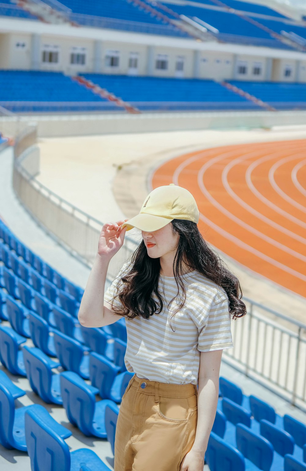 a woman standing in front of a blue stadium