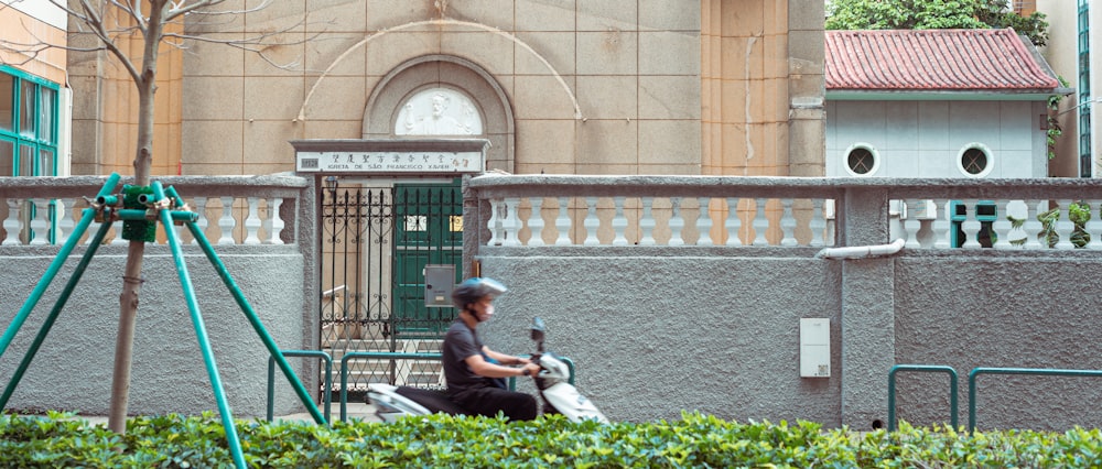 a man sitting on a bench in front of a building