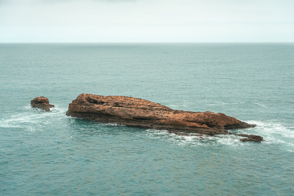 a large rock in the middle of the ocean