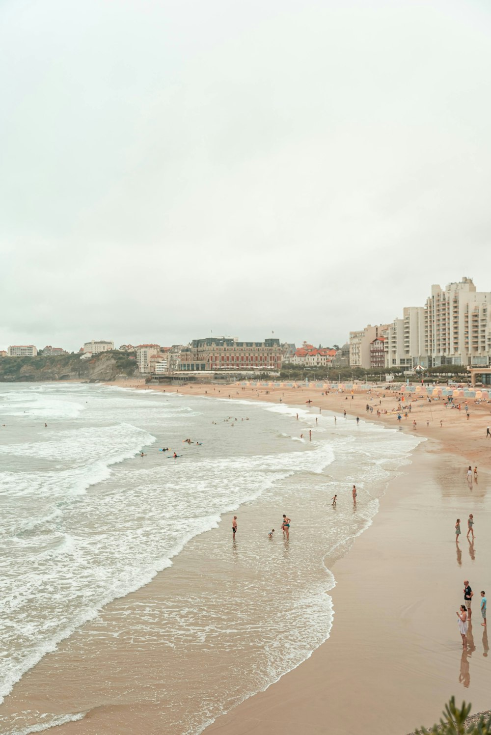 a group of people standing on top of a sandy beach