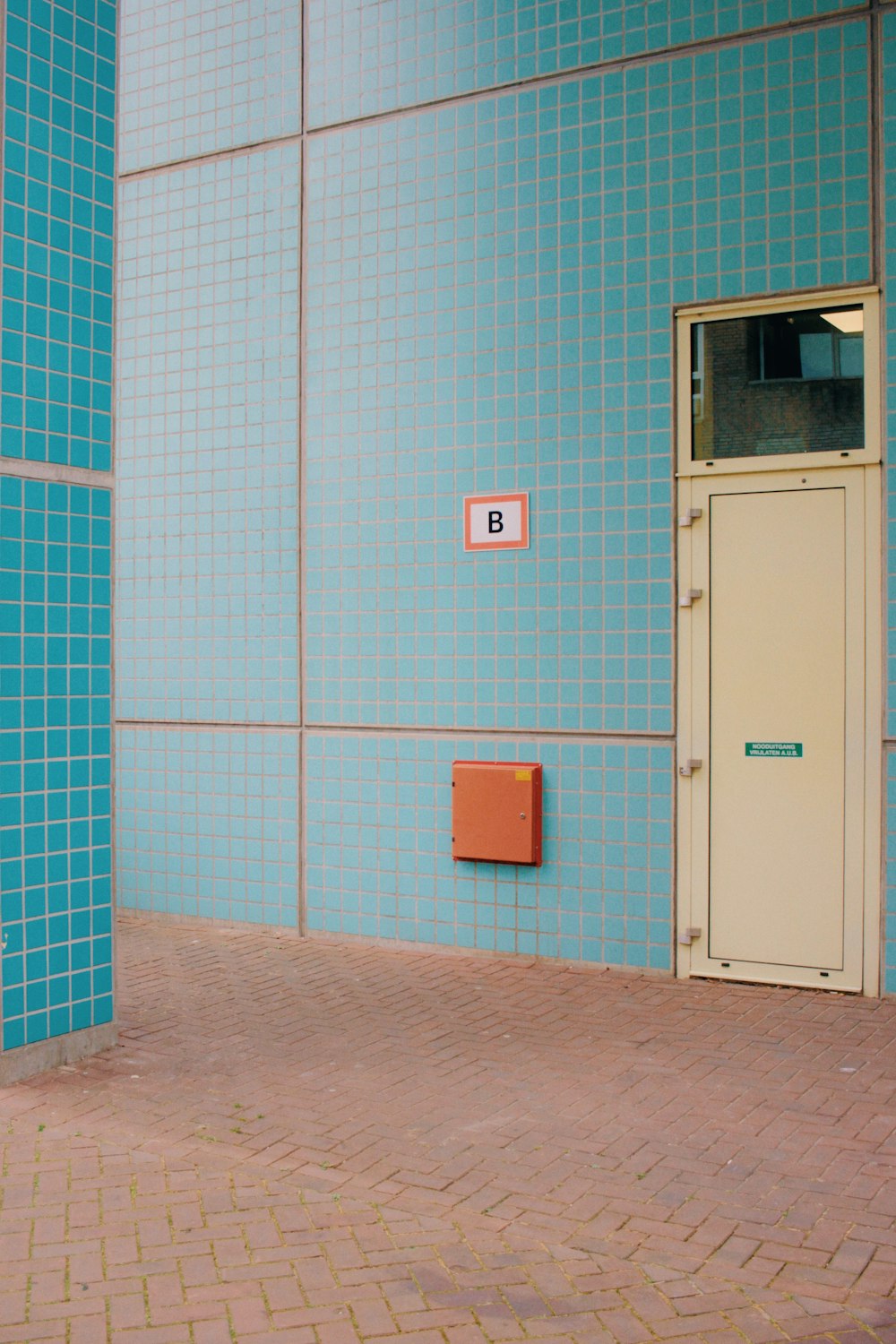 a blue wall with a door and a brick floor