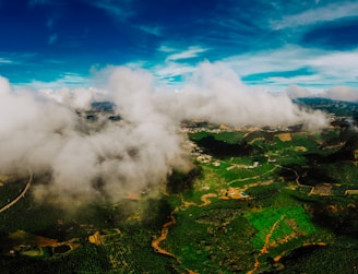 Aerial view of a lush green Brazilian farm with rolling hills under a clear blue sky.