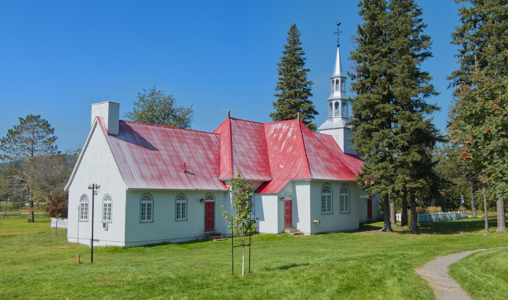 a white church with a red roof and a steeple