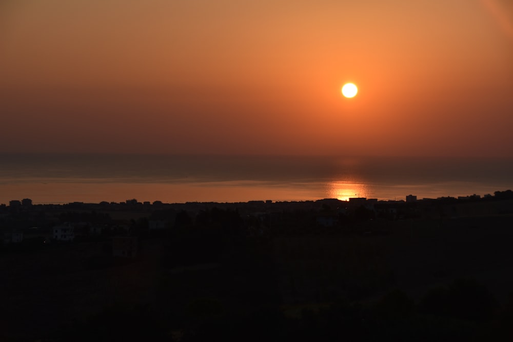 the sun is setting over the horizon of a large body of water