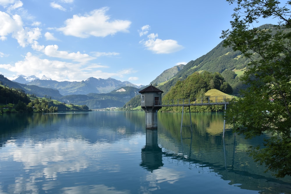 a lake with a birdhouse in the middle of it