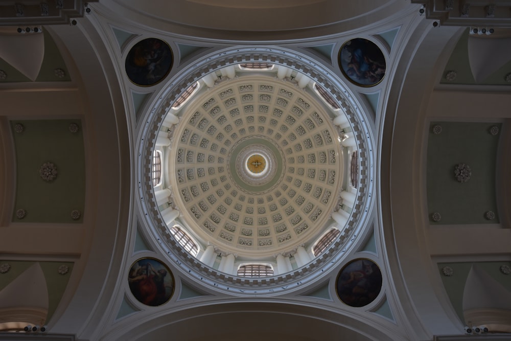the ceiling of a building with a dome and paintings on it