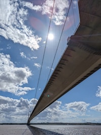 A detailed illustration of the Mackinaw Bridge stretching over clear blue waters under a bright sky.
