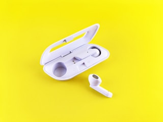 A pair of wireless earbuds resting on a charging case with a vibrant background.