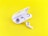 A pair of white wireless earbuds are placed on a vibrant yellow background. One earbud is seated inside an open charging case, while the other rests outside, displaying its speaker mesh.