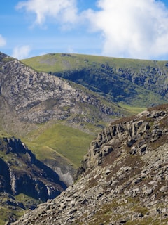 A panoramic view of rugged mountain peaks with clouds drifting through the valleys below