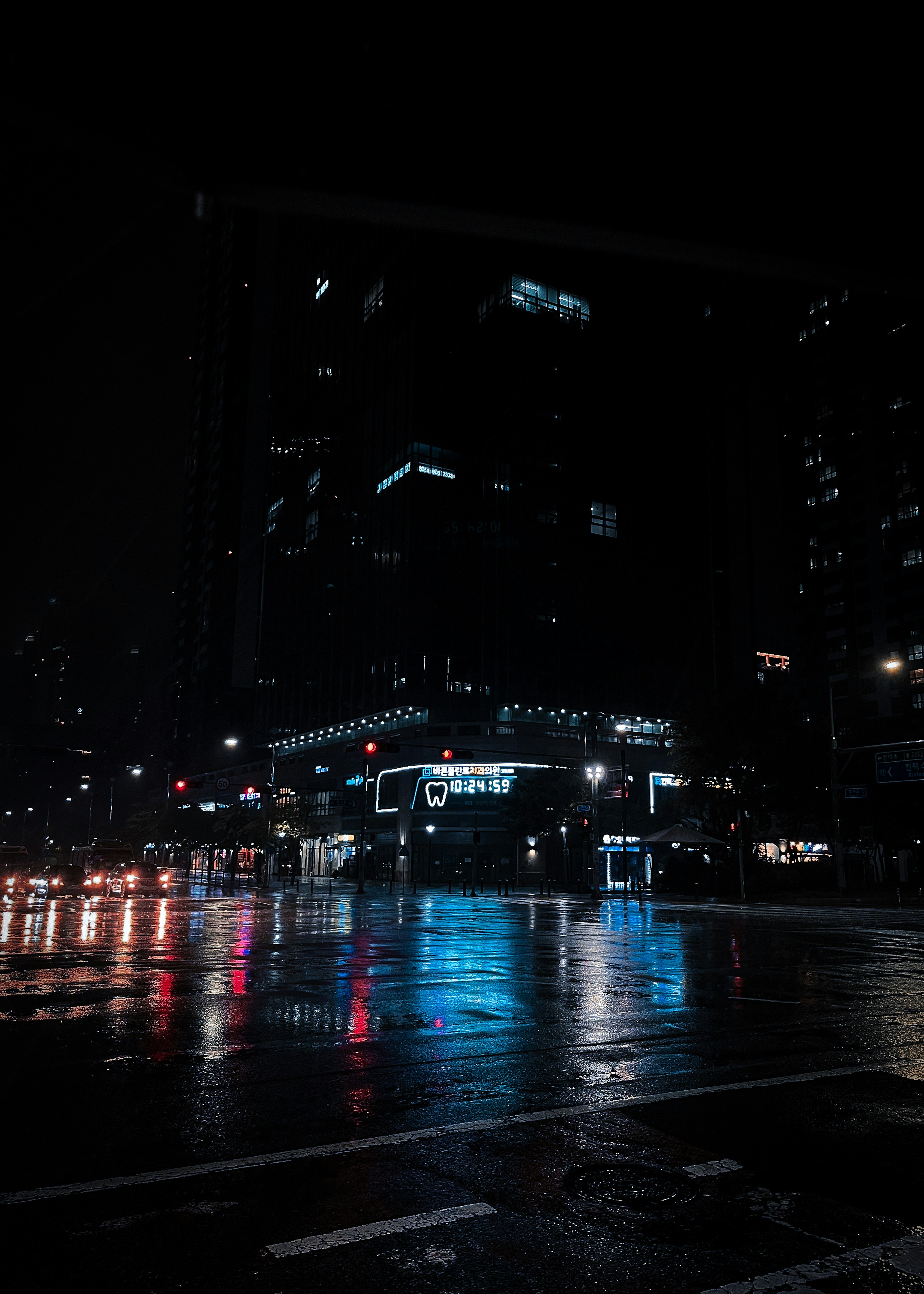 Urban nighttime scene with neon reflections on wet dark streets