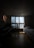 A cozy, well-lit room with a bed, desk, and window showcasing a view of the city.