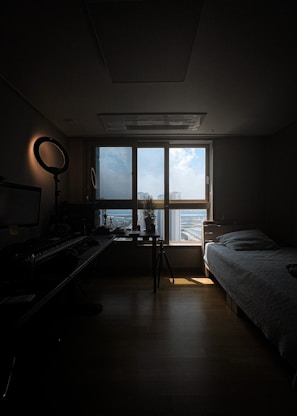 Well-lit room with a desk area and large window overlooking the city.