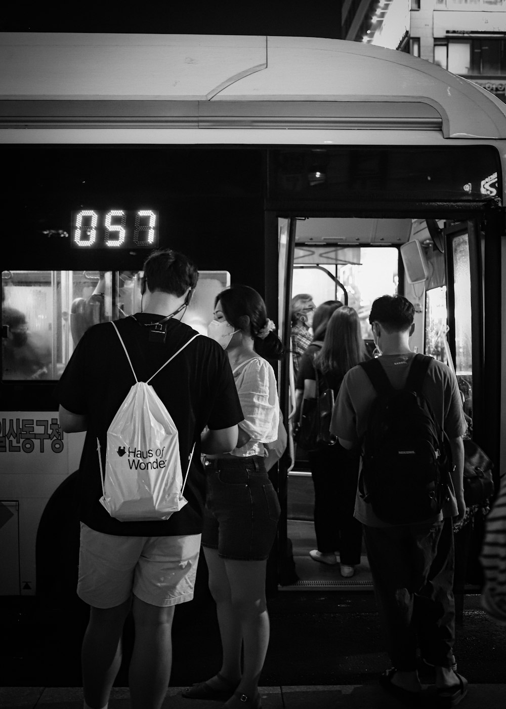 Una foto in bianco e nero di persone che salgono su un autobus