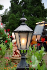 a street light sitting in the middle of a garden