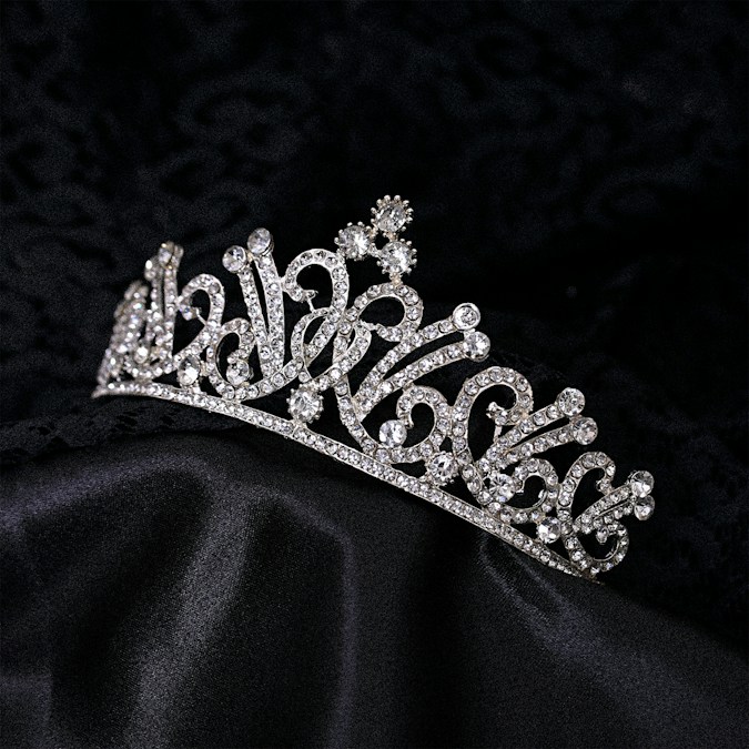 Un diadème orné de strass posé sur un tissu de velours noir, symbole des concours de beauté