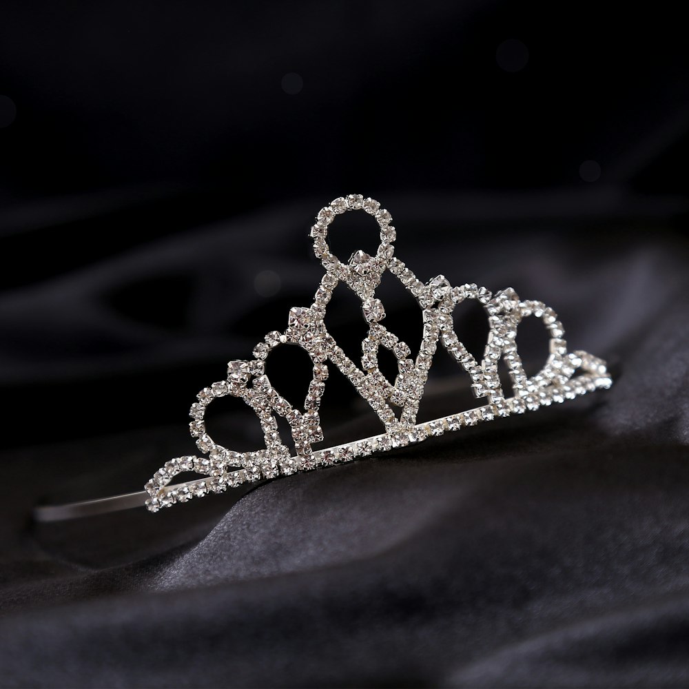 a tiara on a black cloth with a black background