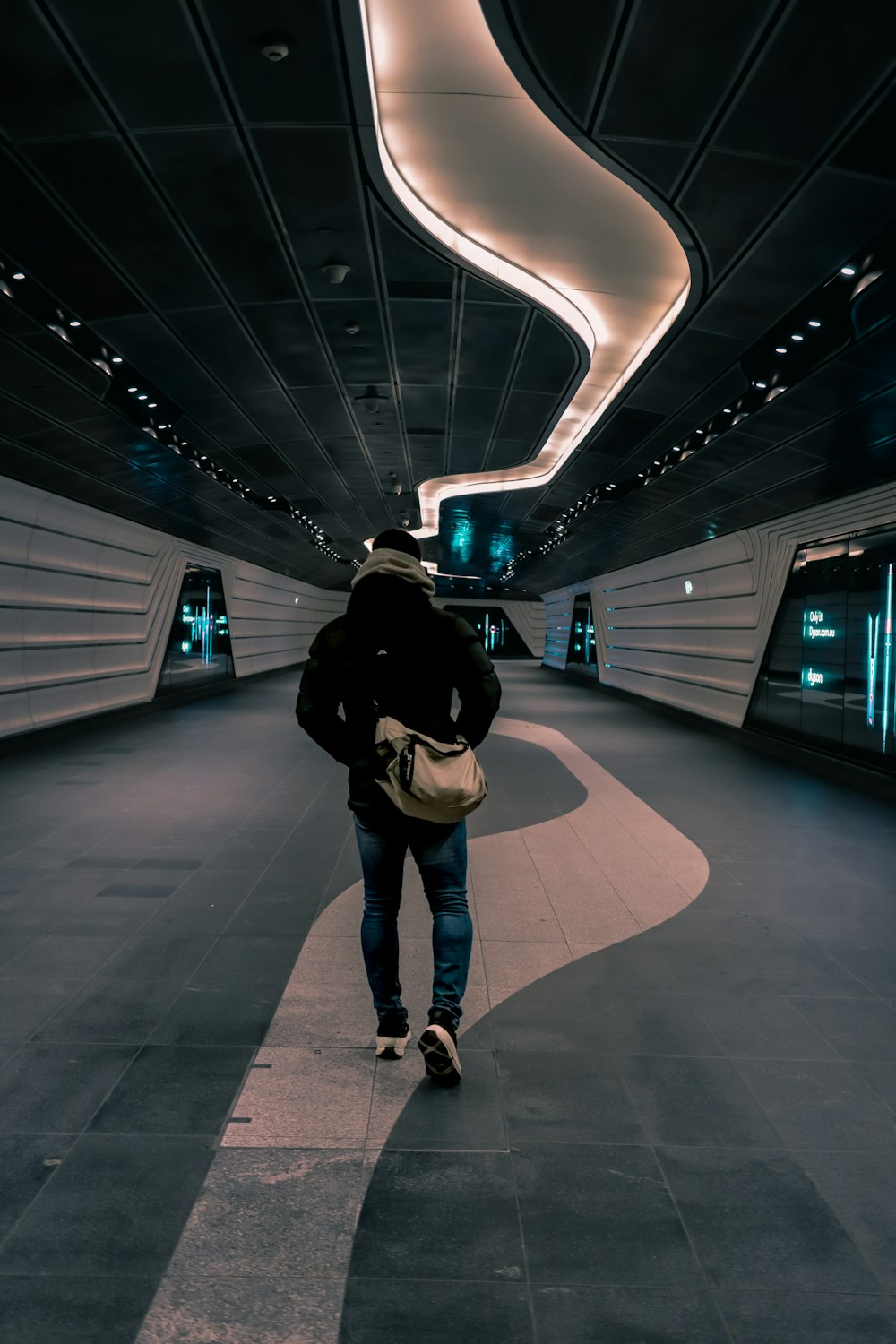 a man is walking down a tunnel carrying a bag