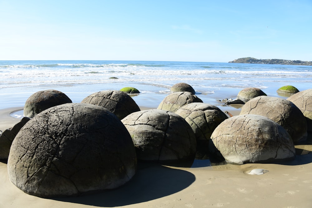 a group of large rocks sitting on top of a sandy beach