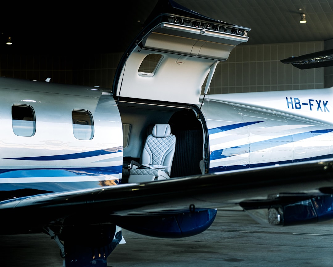 an airplane with its door open sitting in a hanger, Pilatus PC-12 stands with open doors in hangar at Zurich airport