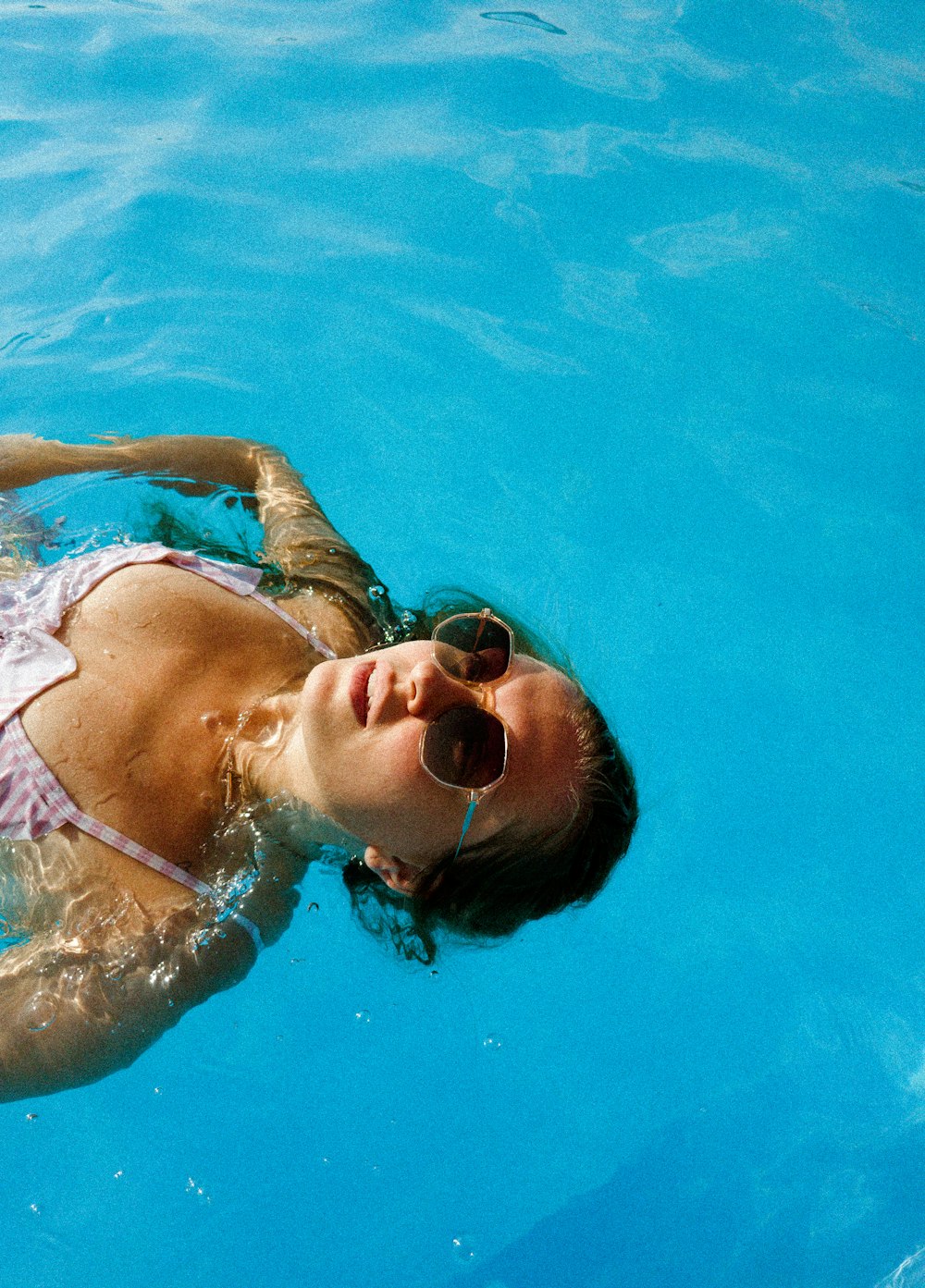a woman in a bikini swimming in a pool