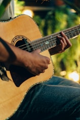 Close-up of hands playing an acoustic guitar in warm natural light