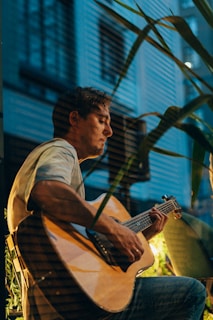 a man sitting in a chair playing a guitar