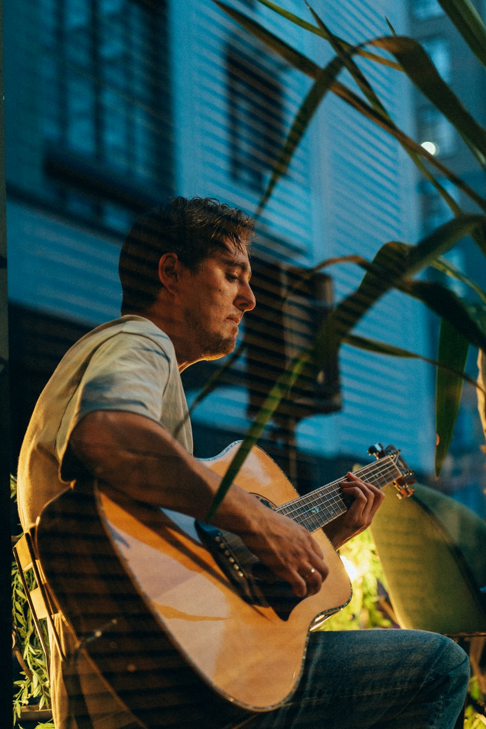 a man sitting in a chair playing a guitar