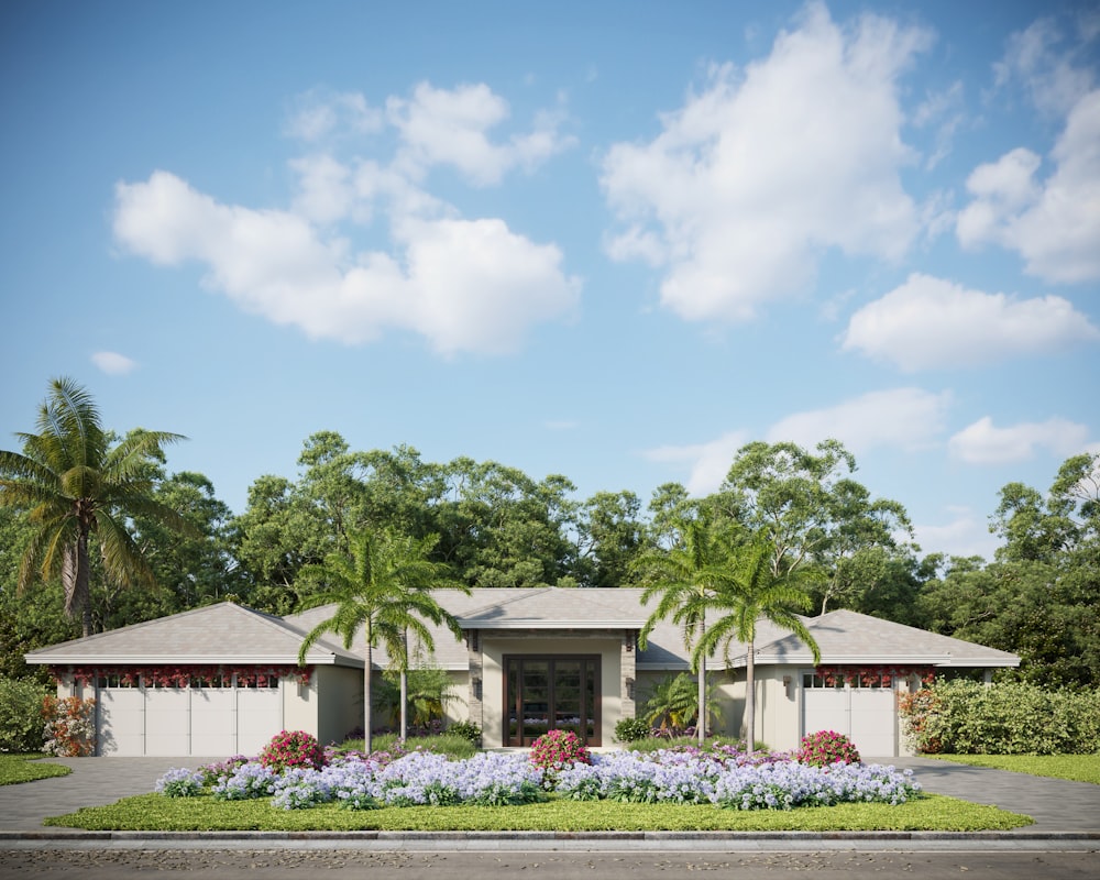 a house with palm trees and blue flowers in front of it