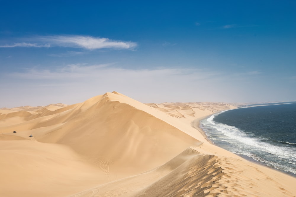 a sandy beach with a body of water in the distance