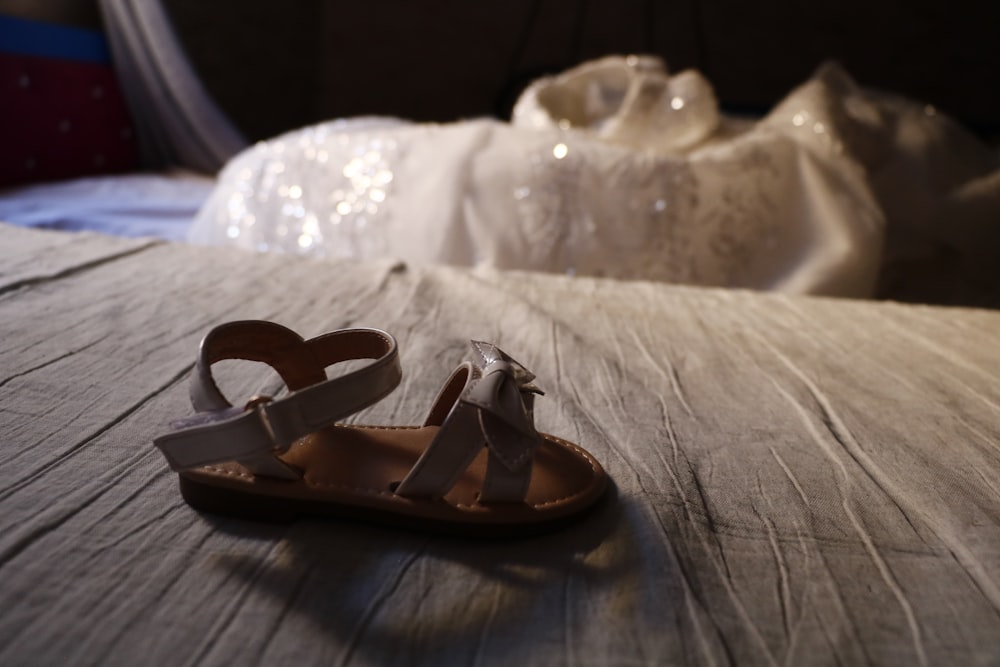 a pair of sandals sitting on top of a bed