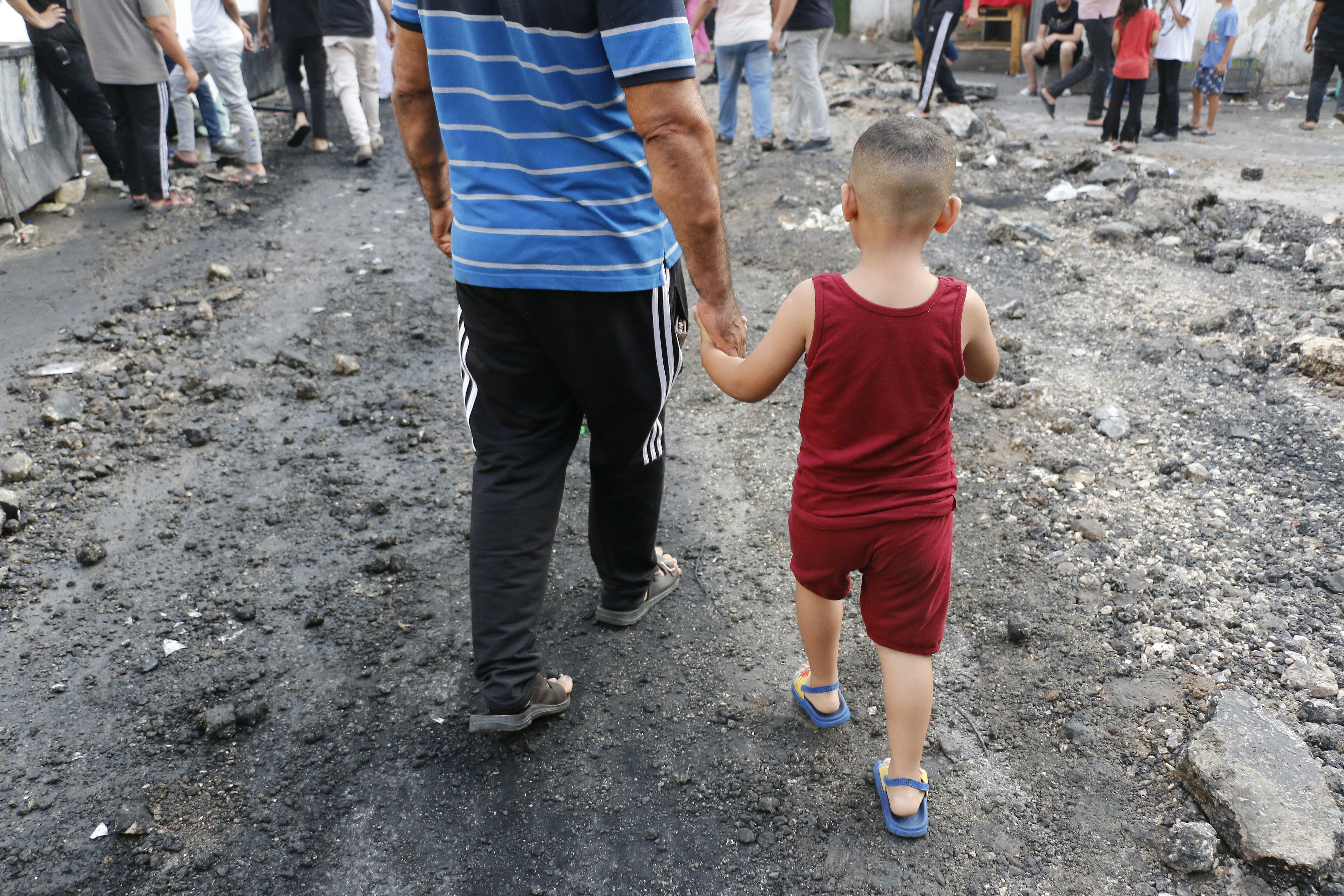 a man holding the hand of a small child